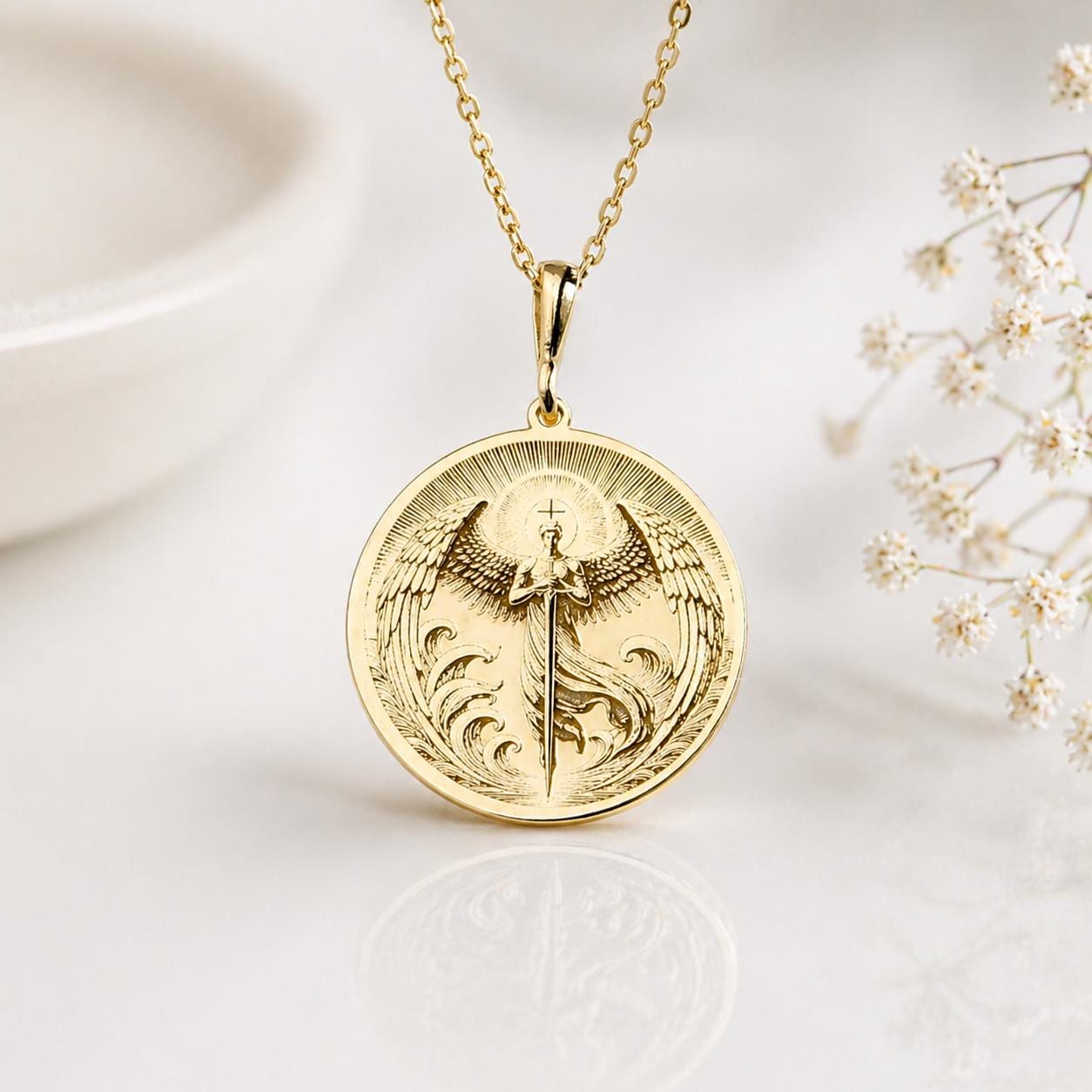 Gold Archangel Michael sword medallion necklace on a soft ivory background